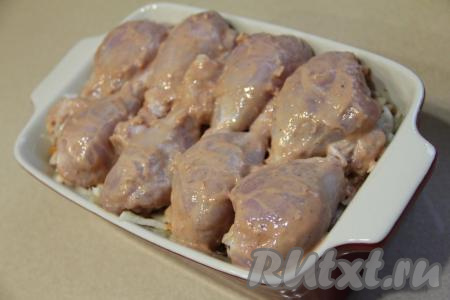 Поверх капусты, смешанной с морковью и луком, выложить промариновавшиеся куриные ножки.