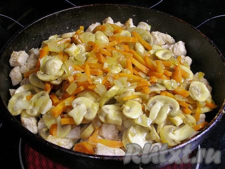 Перекладываем в сковородку с мясом обжаренные лук с морковью и шампиньонами, перемешиваем.
