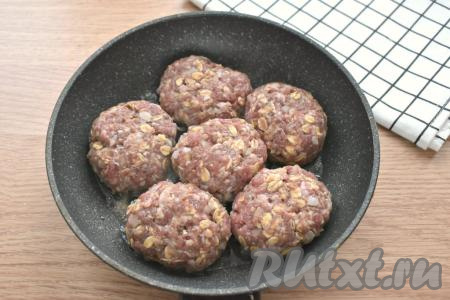 Из получившегося мясного фарша с овсяными хлопьями формируем небольшие котлетки (я сформировала 6 штук). Выкладываем заготовки котлет в разогретое на сковороде растительное масло. Жарим на среднем огне с одной стороны 5 минут.