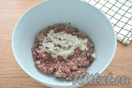 В отдельную миску выкладываем мясной фарш и добавляем к нему мелко нарезанный (или пропущенный через мясорубку) репчатый лук.