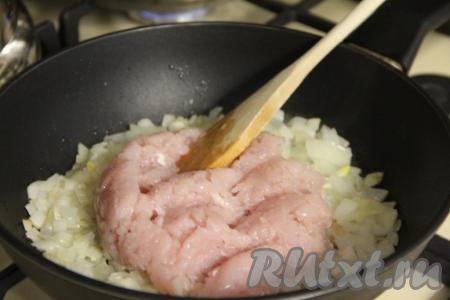 К обжаренному луку выложить куриный фарш, перемешать.