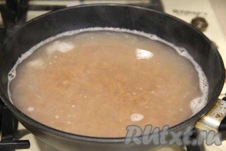 В сковороду с гречкой влить 600 миллилитров горячей воды. 
