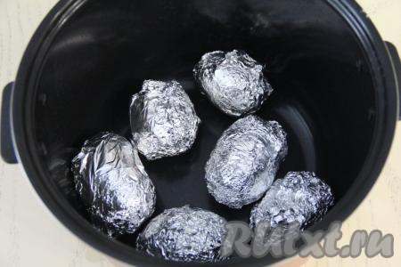 Картошку, завёрнутую в фольгу, выложить в чашу мультиварки. Закрыть крышку и выставить режим "Выпечка" на 1 час.