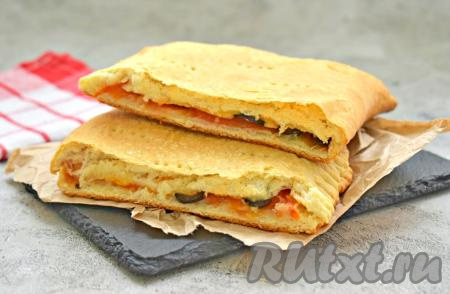 Вкусную, сытную закрытую пиццу достаём из духовки, нарезаем на кусочки и угощаемся. Такая выпечка из слоёного теста хороша и горячей, и полностью остывшей.