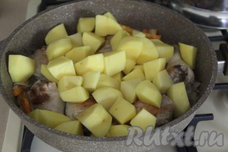 Картошку очистить, нарезать на средние кусочки и добавить в сковороду.