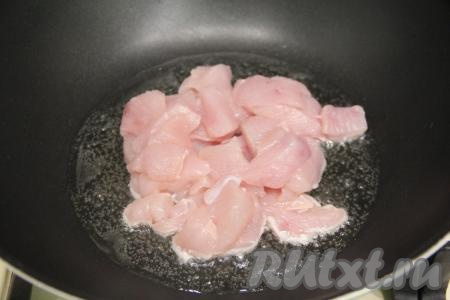 Куриное филе вымыть, обсушить, нарезать на кусочки среднего размера. В глубокой сковороде разогреть растительное масло, после этого убавить огонь до среднего, выложить куриное мясо.