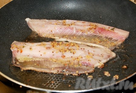 В сковородке соединить растительное и сливочное масла, раскалить ее и выложить рыбное филе. Обжаривать филе сельди с каждой стороны по 1-2 минуты на умеренно сильном огне.