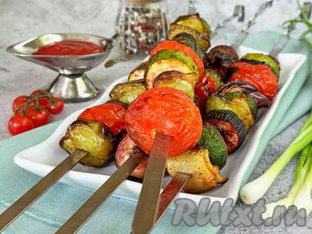 Вкусный, яркий, сочный овощной шашлык убрать с мангала и прямо на шампурах подать к столу.