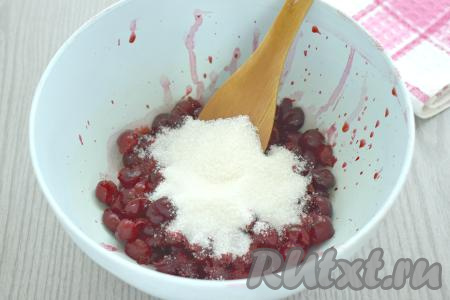 Подготовленную вишню без косточек выкладываем в миску, всыпаем сахар, перемешиваем и оставляем на 10-15 минут, чтобы ягоды выделили сок.