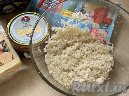 Подготовить продукты для приготовления суши-пирога с крабовыми палочками в духовке. Рис (у меня - рис для суши) выложить в сито, хорошо промыть водой, лишней воде дать стечь. Крабовые палочки разморозить. 