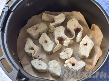 Чашу аэрогриля застелить пергаментом, выложить кусочки минтая. Запекать рыбу в закрытом аэрогриле 15 минут при температуре 180 градусов. 