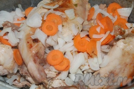 Обжаренные кусочки кролика переложить в жаровню, добавить к нему лук с морковью.