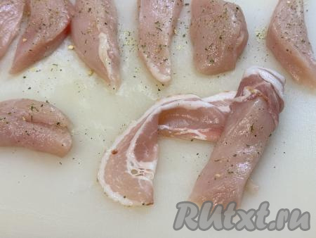 Каждый кусочек куриного филе обмотать полоской бекона, наматывая бекон немного внахлёст. 