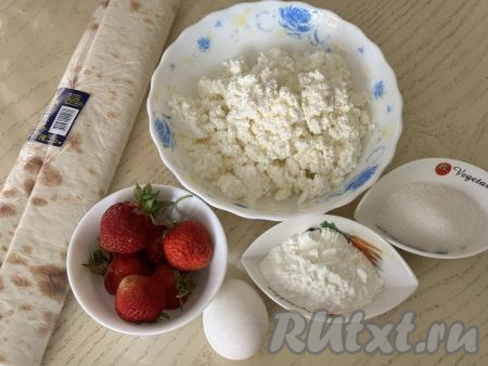 Подготовить продукты для приготовления рулета из лаваша с клубникой и творогом. Творог можно использовать любой жирности и консистенции. Крахмал можно взять как картофельный, так и кукурузный. Эту простую выпечку можно приготовить и со свежей клубникой, и с замороженной. Свежие ягоды нужно будет вымыть, удаляя чашелистики. Замороженную клубнику, если на ней нет большого количества льда, нужно слегка разморозить. 