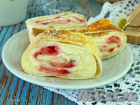 Готовый рулет из лаваша с нежнейшей начинкой из творога и клубники достать из духовки, переложить на тарелку, дать слегка остыть, нарезать на кусочки и подать к столу. Эта простая, аппетитная выпечка хороша на вкус и горячей, и полностью остывшей. 