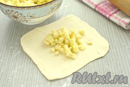 Яблоки очищаем от кожуры, нарезаем на маленькие кубики, удаляя семенную коробку с семечками. Зрительно делим нарезанные яблоки на 6 равных частей (по количеству частей теста). В центр каждого квадрата выкладываем одну часть нарезанных яблок (это примерно 1 полная столовая ложка нарезанных яблок).