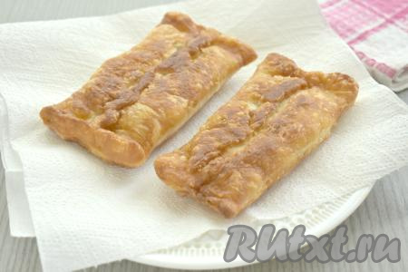 Жареные слоёные пирожки с яблочной начинкой со сковороды выкладываем на бумажное полотенце, чтобы убрать лишнее масло.
