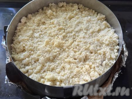 Равномерно разложить отложенную ранее песочную крошку поверх творожно-клубничного слоя. 