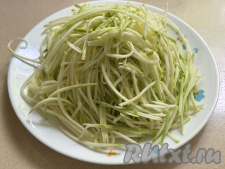 С помощью тёрки для корейской моркови натереть кабачок на длинные полоски.