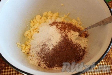 Затем добавьте часть муки с разрыхлителем, какао и корицу, тщательно перемешайте. Затем постепенно добавляя оставшуюся муку и перемешивая вначале ложкой, а затем руками, замесите тесто.