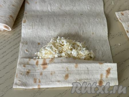 Узкую сторону лаваша, ближе к которому выложена начинка, подвернуть на начинку.