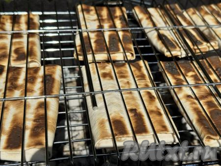 Поместить решётку с конвертиками на мангал с раскалёнными углями, прямого огня быть не должно. Жарить лаваш с творогом и сыром в течение 5 минут (до подрумянивания с двух сторон), используя жар от углей, часто переворачивая решётку. Время приготовления во многом зависит от жара мангала. 