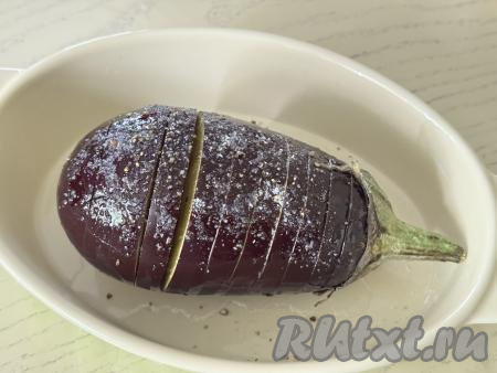 Посолить баклажан сверху и в надрезах по вкусу. Можно присыпать баклажан сверху чёрным молотым перцем (или специями по вкусу).