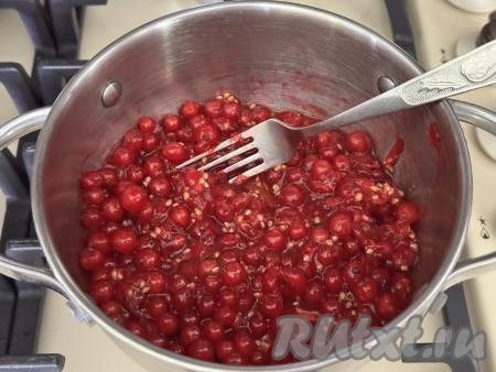 200 грамм подготовленной красной смородины выложить в кастрюлю с толстым дном, слегка размять ягоды вилкой, поставить на средний огонь. 