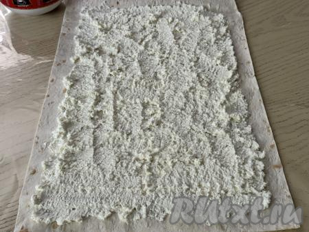 Отступая от краёв лаваша по 2 сантиметра, смазать равномерно лаваш творожной начинкой. 