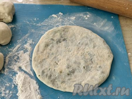 Перевернуть мешочек швом вниз и аккуратно растянуть тесто руками в лепёшку. Затем раскатать скалкой в тонкую лепёшку диаметром примерно 18 сантиметров. 