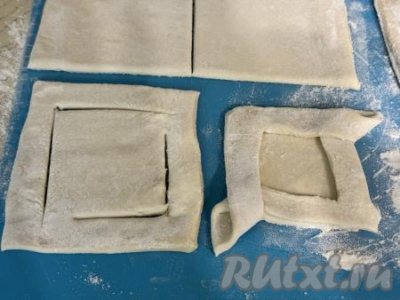 Теперь из квадратных заготовок нужно сформировать открытые слойки. Для этого, отступив от краёв теста примерно по 1 сантиметру, нужно в противоположных углах квадрата сделать надрезы так, чтобы они не пересекались (то есть разрезы не доходили до оставшихся углов квадрата), как на фото. Перекинуть получившиеся полоски теста на противоположные стороны. У нас получится слойка с аккуратными и красивыми бортиками.