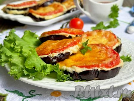 Аппетитные баклажаны, покрытые помидорами, смесью майонеза с чеснока и аппетитной шапочкой из сыра, достать из духовки, переложить на тарелку и в тёплом виде в качестве гарнира или закуски подать к столу. Просто, сытно и очень вкусно, попробуйте!