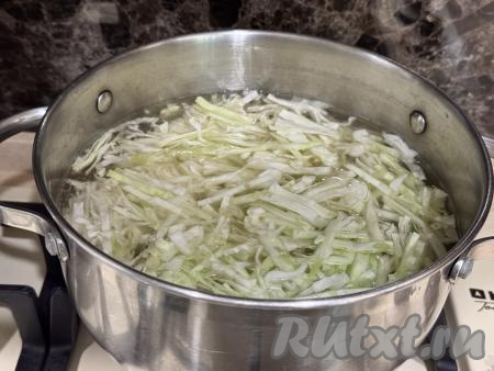 Прежде всего нужно вымытое мясо на кости выложить в кастрюлю, залить 2 литрами воды и поставить на сильный огонь. После закипания бульона, убрав с поверхности пену, отварить мясо на небольшом огне до готовности. В качестве мяса я взяла куриный окорочок и отваривала его в течение 40 минут с момента закипания воды, если вы возьмёте свинину, тогда на варку с момента начала кипения воды потребуется 1 час, говядину нужно будет варить 1,5 часа. Готовое мясо достать из бульона, оставить остывать. Бульон, если нужно, процедить, вернуть его в кастрюлю. Поставить кастрюлю с бульоном на огонь, довести до кипения. В закипевший бульон выложить капусту, нарезанную на тонкие полоски, и очищенную картошку, нарезанную на средние кубики, ещё раз дать закипеть и варить на небольшом огне 10 минут. 