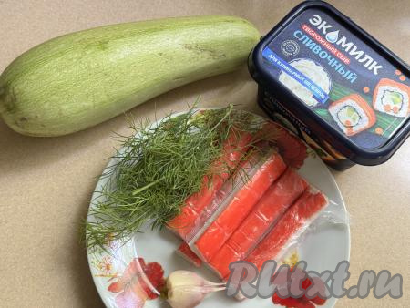 Подготовить продукты для приготовления рулетиков из кабачков с крабовыми палочками. Для этого блюда нужно брать молоденький кабачок с тонкой кожицей и мелкими семечками. Кабачок нужно вымыть, отрезать кончики с двух сторон. Разморозить крабовые палочки при комнатной температуре, очистить от слюды. 