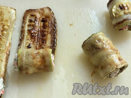 Начиная со стороны с начинкой, свернуть полоску из кабачка в рулет. 