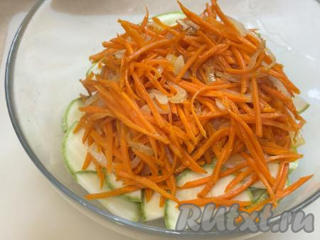 В миску с кабачками выложить горячие жареные морковку, лук и чеснок. 