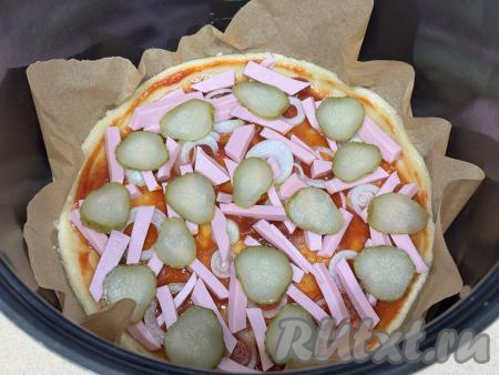 Затем поверх колбасы разложить маринованный огурец, нарезанный на тонкие кружочки.