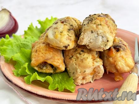 Форму с готовыми рулетиками из куриного филе с грибами и сыром достать из духовки, переложить на тарелку и, дополнив гарниром, свежей зелень, подать к столу. 