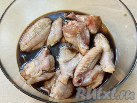Тщательно перемешать куриные крылышки, покрывая их мёдом и соевым соусом со всех сторон. Оставить крылья мариноваться минут на 30-40. В течение этого времени 2-3 раза крылышки можно перемешать, чтобы они равномерно пропитались маринадом. Соевый соус достаточно солёный, поэтому соль можно не добавлять.