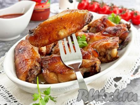 Форму с готовыми куриными крыльями достать из духовки. Разложить крылышки по тарелкам и, дополнив гарниром, в горячем виде подать к столу. Благодаря тому, что крылья и мариновались, и запекались в соевом соусе с мёдом, они получились сочными, вкусными, глазированными. Отличное мясное блюдо для семейного обеда или ужина, попробуйте!