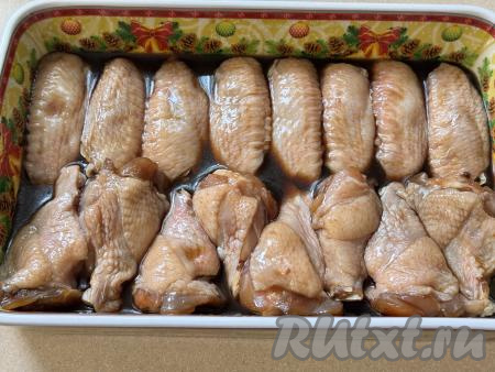Выложить замаринованные крылья в форму в один слой, влить весь маринад поверх мяса. 