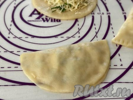Частью круга без начинки накрыть сторону круга с начинкой, пряча начинку внутрь и формируя чебурек.  