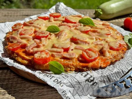 Кабачковую пиццу с сочной, аппетитной начинкой из колбасы, помидоров и сыра в горячем виде подать к столу. 