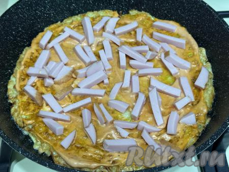 Колбасу нарезать на брусочки, выложить поверх соуса.
