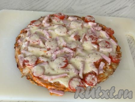 Пиццу из кабачков с колбасой и сыром переложить со сковороды на разделочную доску (или на плоскую тарелку). 