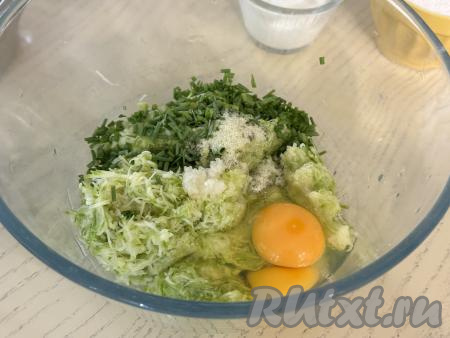 Зелень (у меня - зелёный лук) вымыть, обсушить, мелко нарезать. В миску с кабачковой массой, отжатой от лишнего сока, добавить нарезанную зелень, очищенный чеснок, пропущенный через пресс, и сырые яйца, чёрный молотый перец, соль (добавляя соль, учитывайте, степень солёности сыра, который будет добавляться в дальнейшем). Перемешать массу столовой ложкой до однородности.