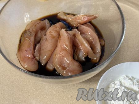 Кусочки мяса курицы выложить в глубокую миску, залить соевым соусом, хорошо перемешать, чтобы филе было покрыто соусом со всех сторон, и оставить на 30 минут. За это время 1-2 раза кусочки мяса нужно перемешать, чтобы они равномерно промариновались. Солить филе не нужно, так как соевый соус достаточно солёный.