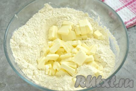 Достаём сливочное масло из холодильника, нарезаем на небольшие кусочки (или натираем на крупной тёрке), добавляем в миску с мучной смесью.