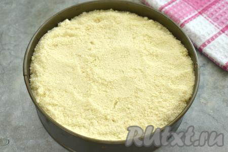 Начинку из творога и абрикосов полностью засыпаем оставшейся песочной крошкой.