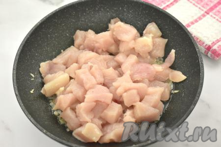 Пока обжаривается лук, моем куриное филе, немного обсушиваем, нарезаем на небольшие кусочки, солим, перемешиваем. К луку, обжаренному до мягкости, выкладываем мясо курицы, перемешиваем.